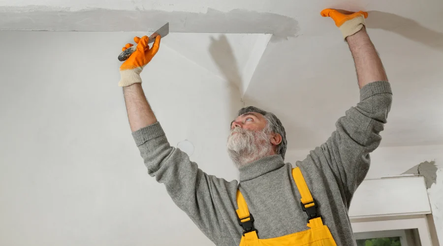 guy fixing stucco ceiling